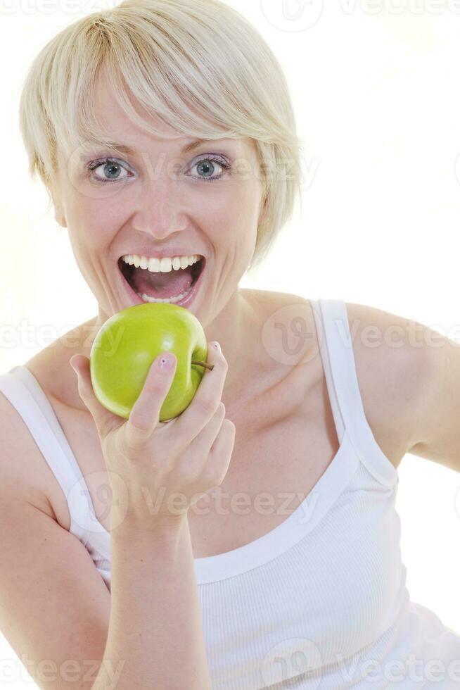 heureuse jeune femme mange une pomme verte isolée sur blanc photo