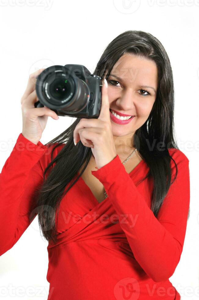 jeune femme tenant un appareil photo à la main prenant une photo isolée