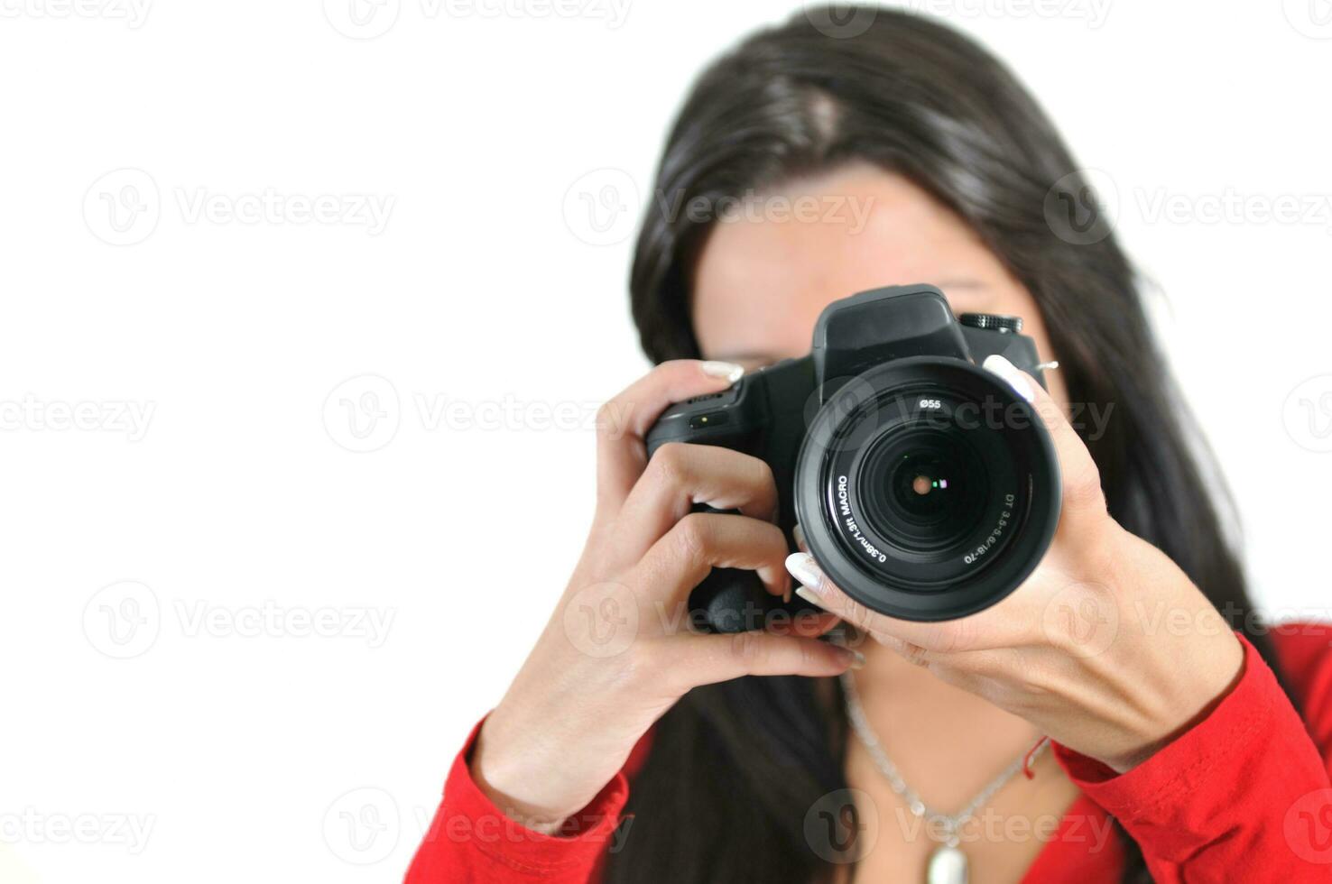 jeune femme tenant un appareil photo à la main prenant une photo isolée