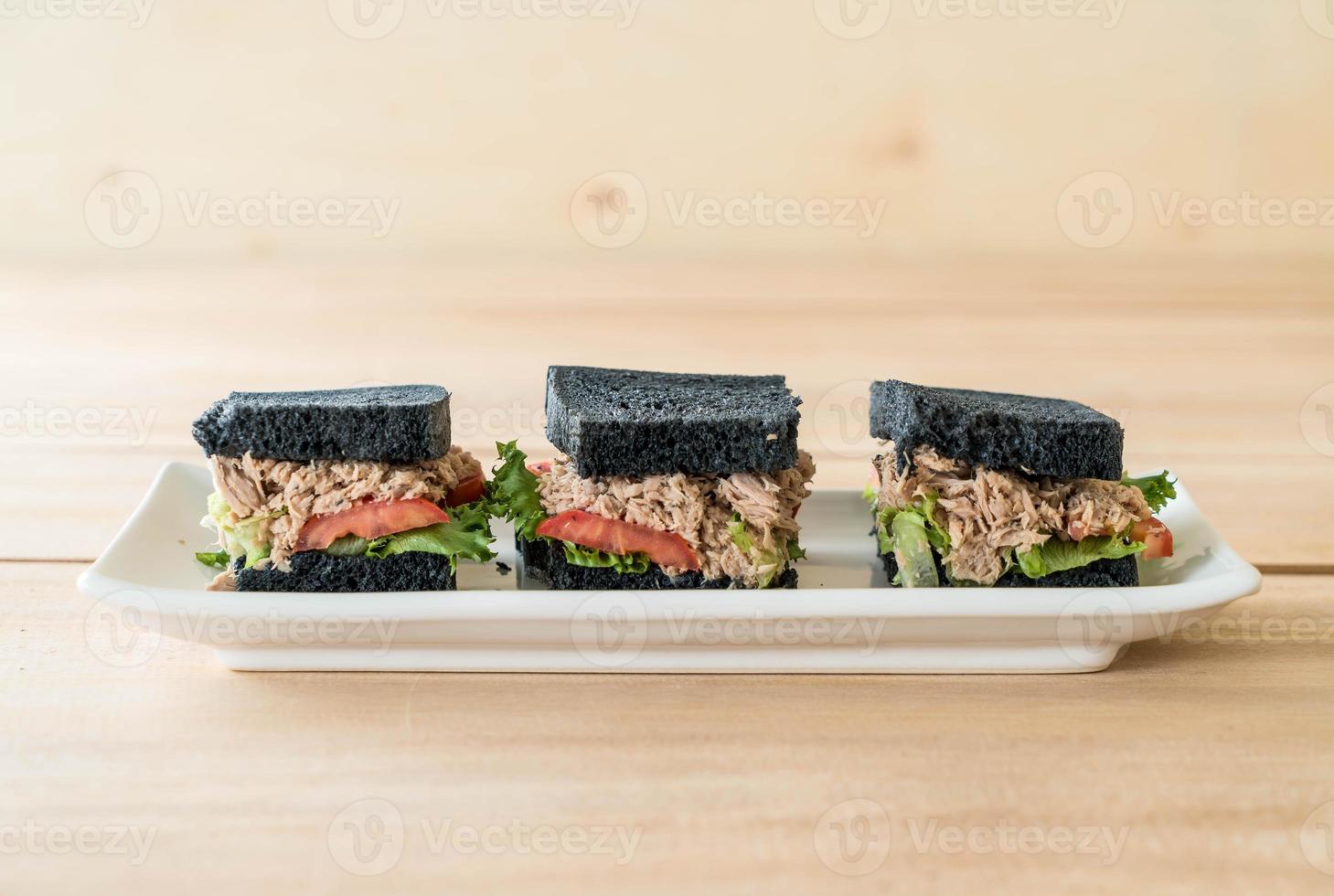 sandwich au charbon de bois au thon sur planche de bois photo