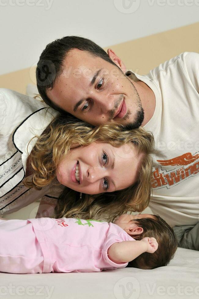 portrait intérieur avec une jeune famille heureuse et un mignon petit bébé photo