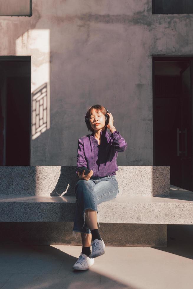 heureuse jeune femme asiatique écoutant de la musique avec des écouteurs photo