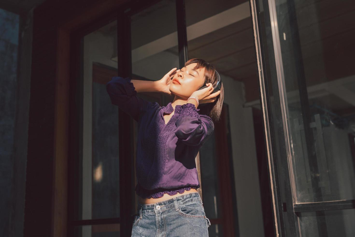 heureuse jeune femme asiatique écoutant de la musique avec des écouteurs photo