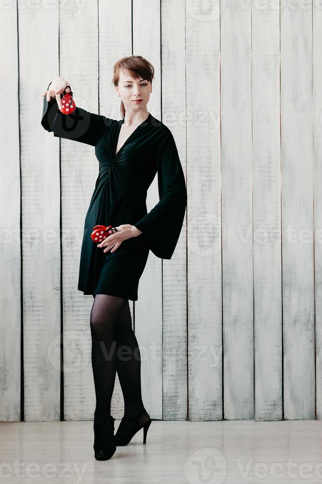 danseuse en robe noire, avec castagnettes rouges, fond clair photo