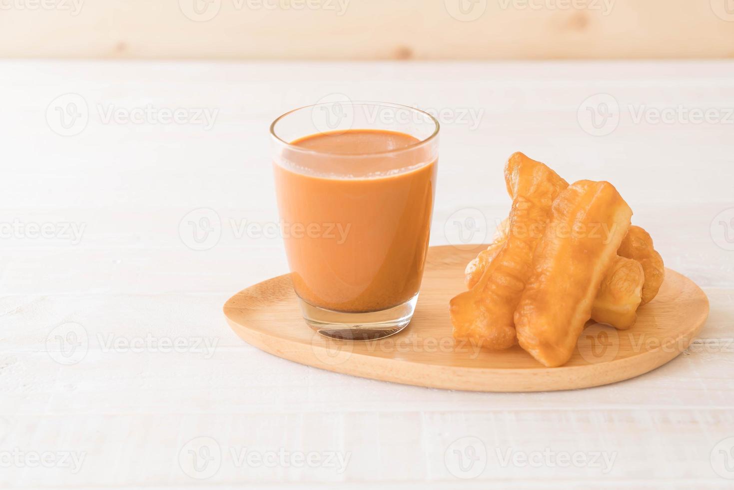 bâton de pâte frit avec du thé au lait sur bois photo