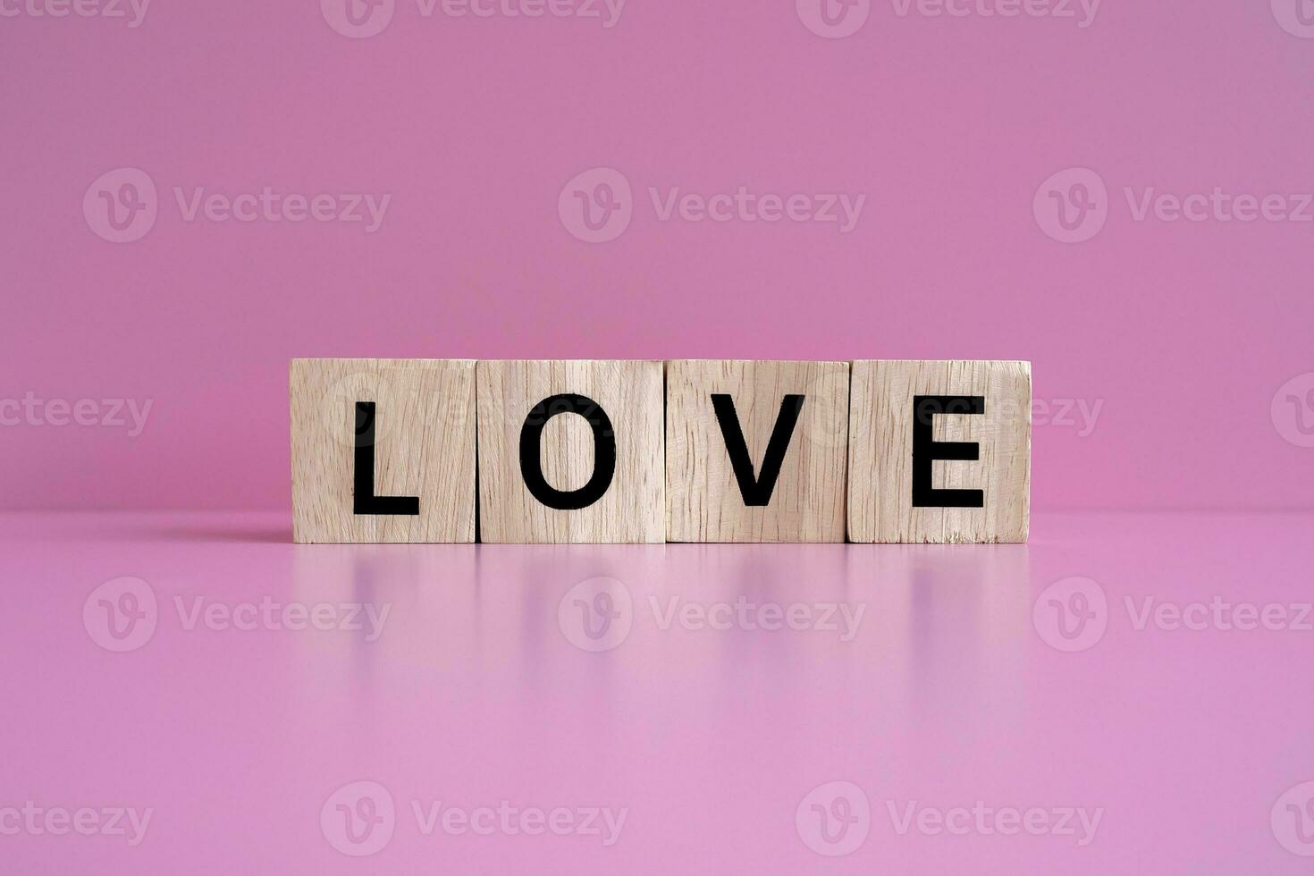 en bois blocs forme le texte l'amour contre une rose Contexte. photo