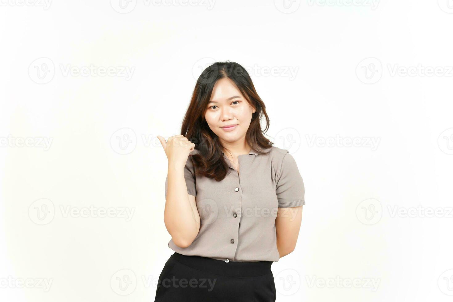 présentation et pointage du produit latéral à l'aide du pouce d'une belle femme asiatique isolée sur blanc photo
