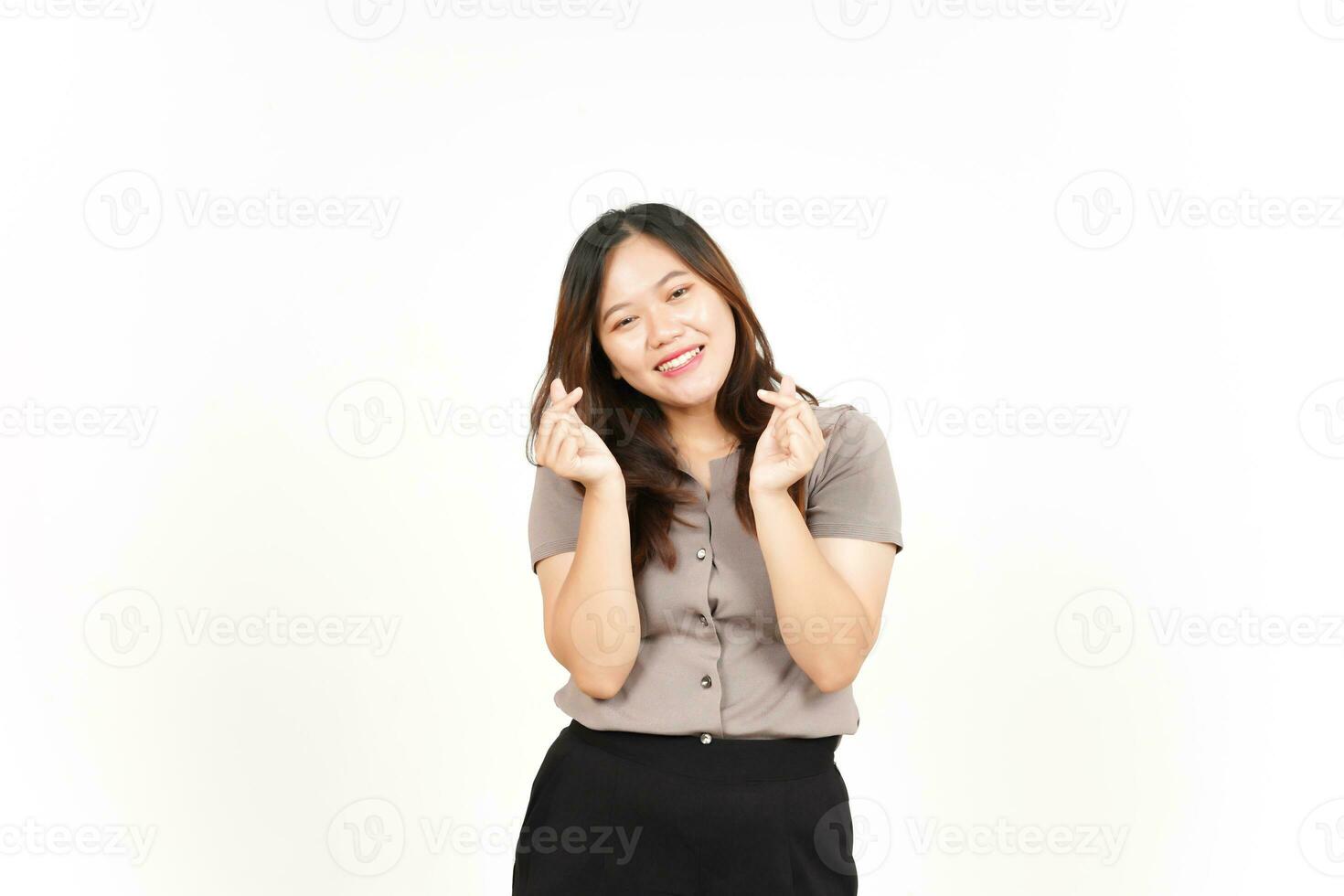 un asiatique femme est montrant le coréen l'amour signe avec une blanc arrière-plan, souriant vivement photo