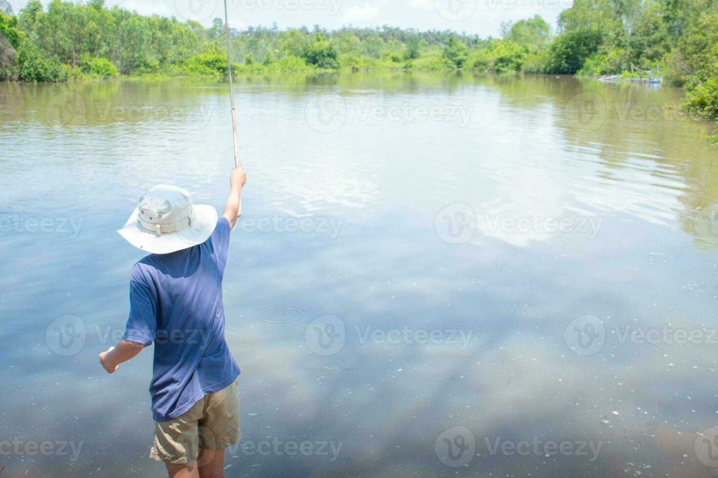 asiatique garçon permanent pêche par rivière en utilisant bambou pêche barre sur magnifique l'eau surface et lever du soleil ,mode de vie de asiatique enfants, mode de vie dans rural Thaïlande,notion de la vie et durabilité. photo