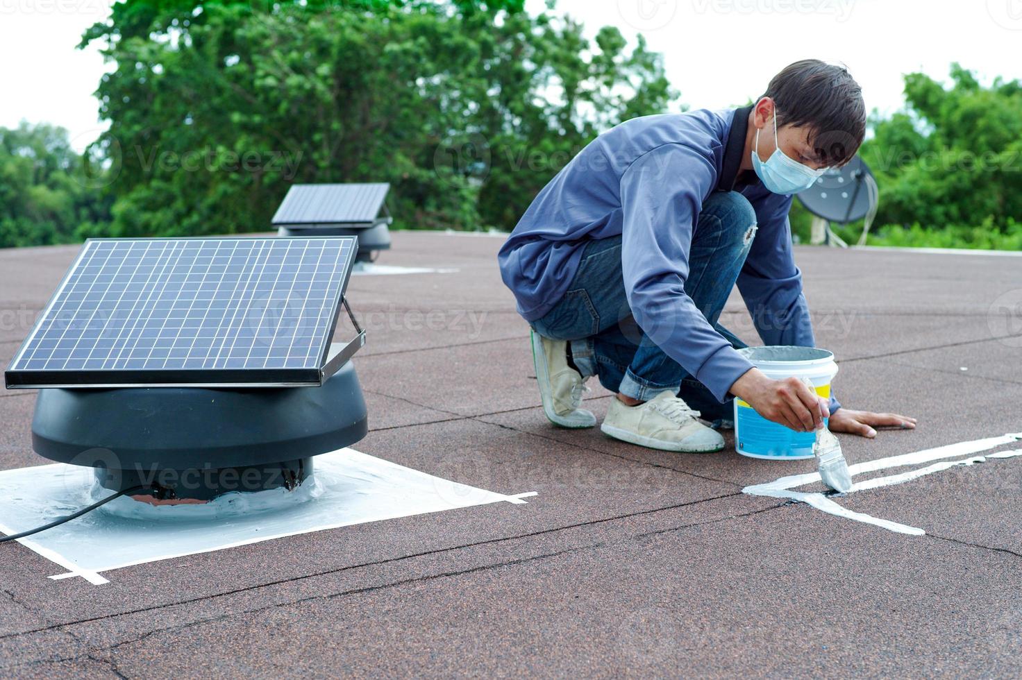 gros plan de la cellule solaire sur le toit avec la fixation d'un travailleur flou de mouvement photo