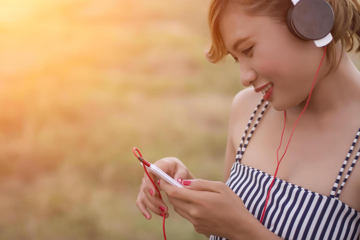 belle femme avec de la musique d'écoute debout dans les champs de fleurs. photo