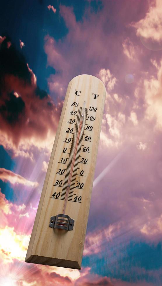 thermomètre en bois sur le ciel, temps chaud photo