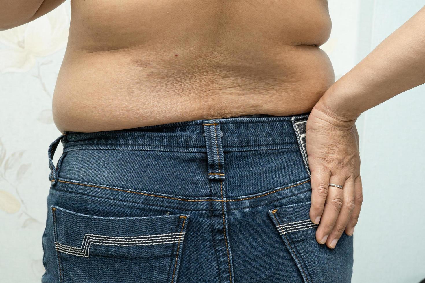 une femme asiatique en surpoids montre un gros ventre au bureau. photo