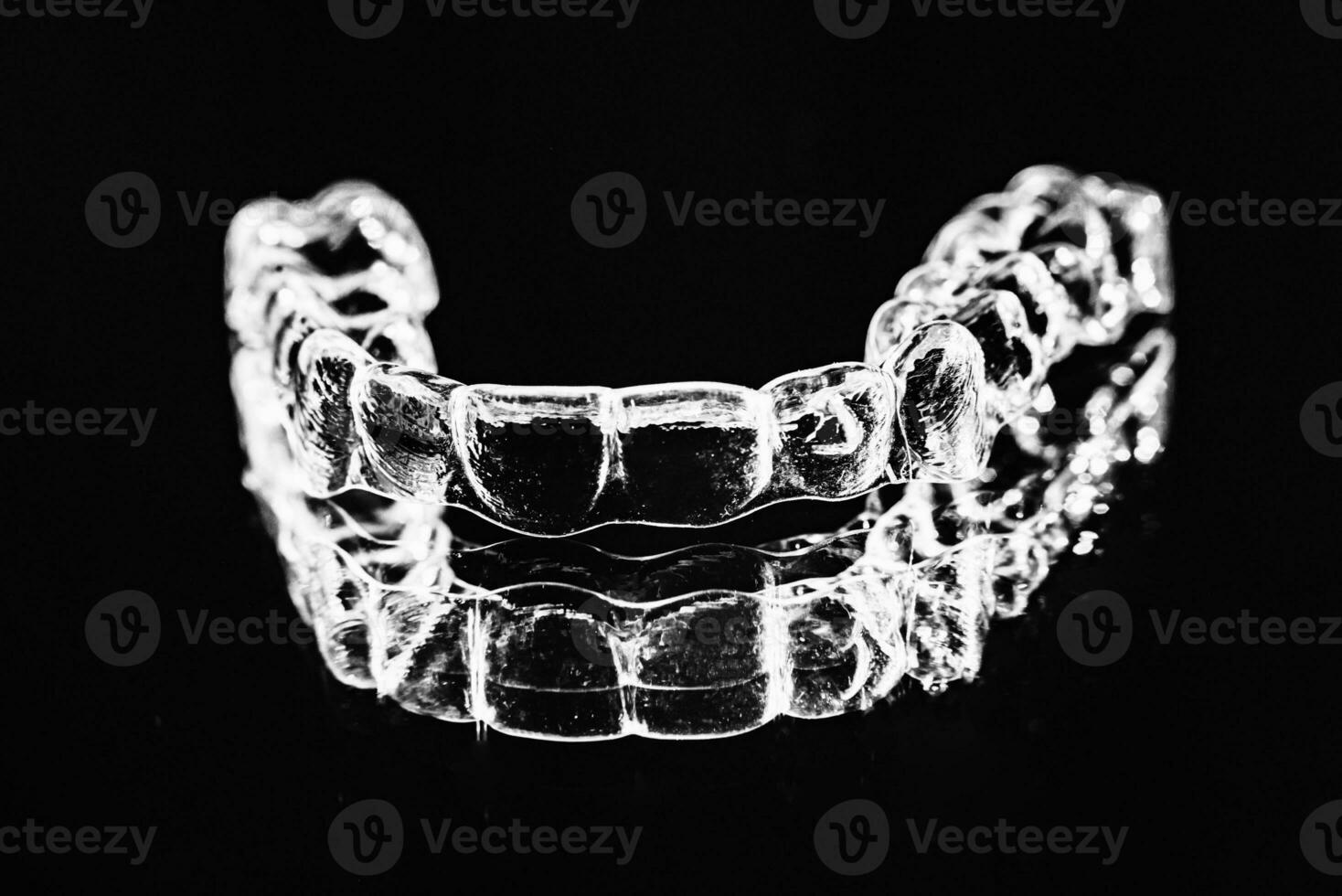 invisible dentaire les dents supports dent aligneurs sur noir Contexte. Plastique un appareil dentaire dentisterie retenues à redresser dents. photo