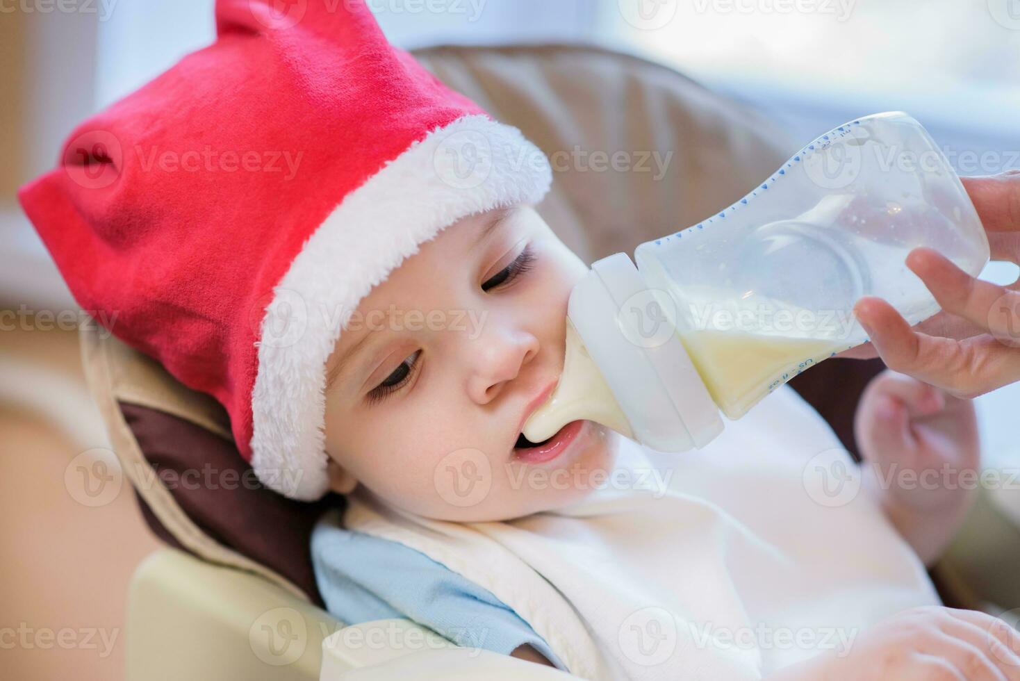 maman alimente le bébé dont Nouveau année chapeau photo