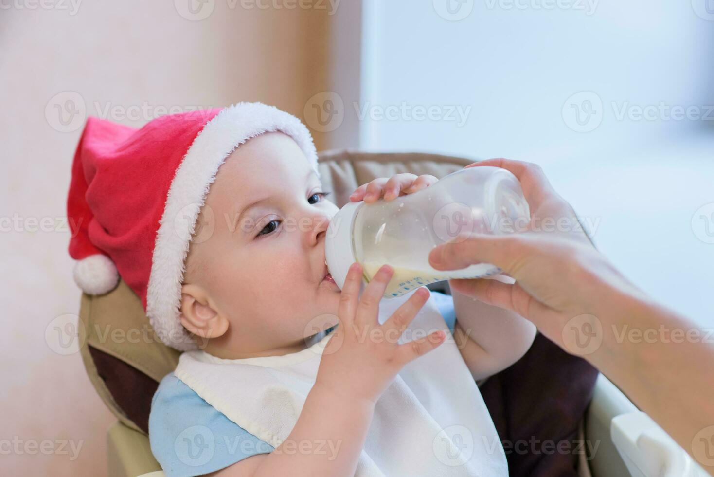 maman alimente le bébé dont Nouveau année chapeau photo