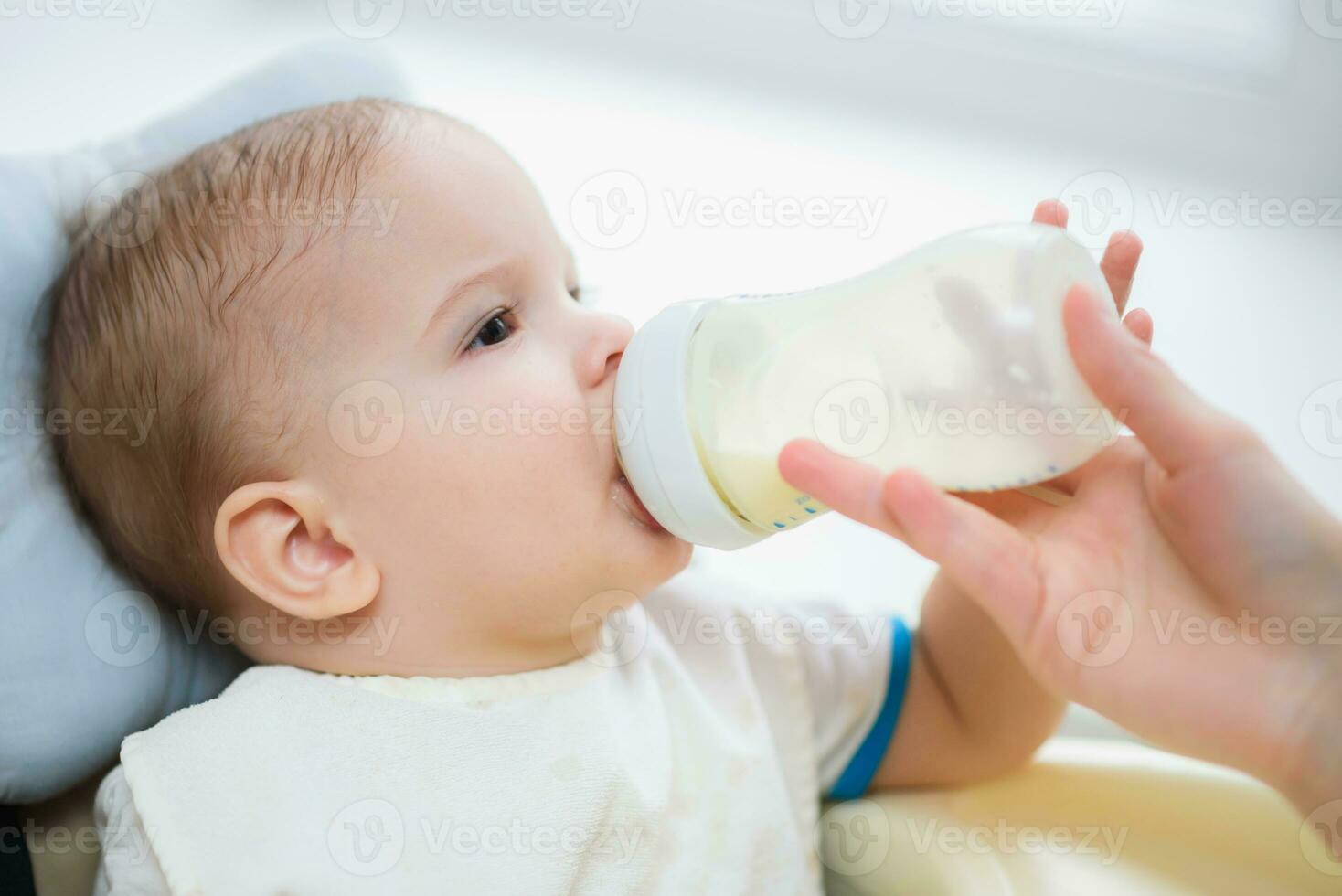 mère alimente bébé de une bouteille de Lait photo