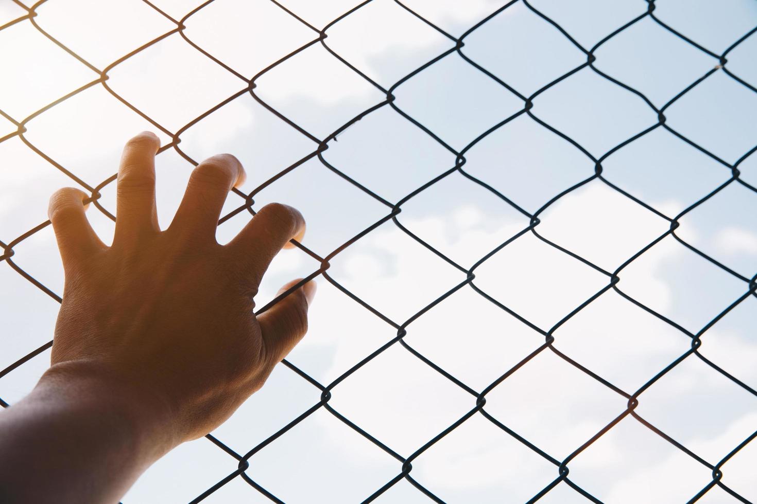 concept d'espoir, main d'homme malheureux triste sans espoir à la prison de clôture en prison, photo
