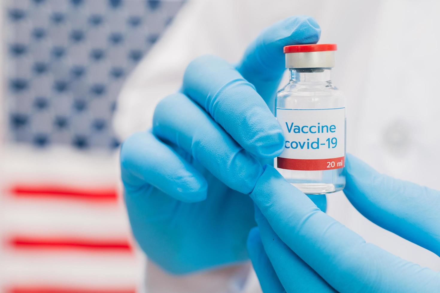 docteur tenant une bouteille de vaccin avec fond de drapeau américain. photo