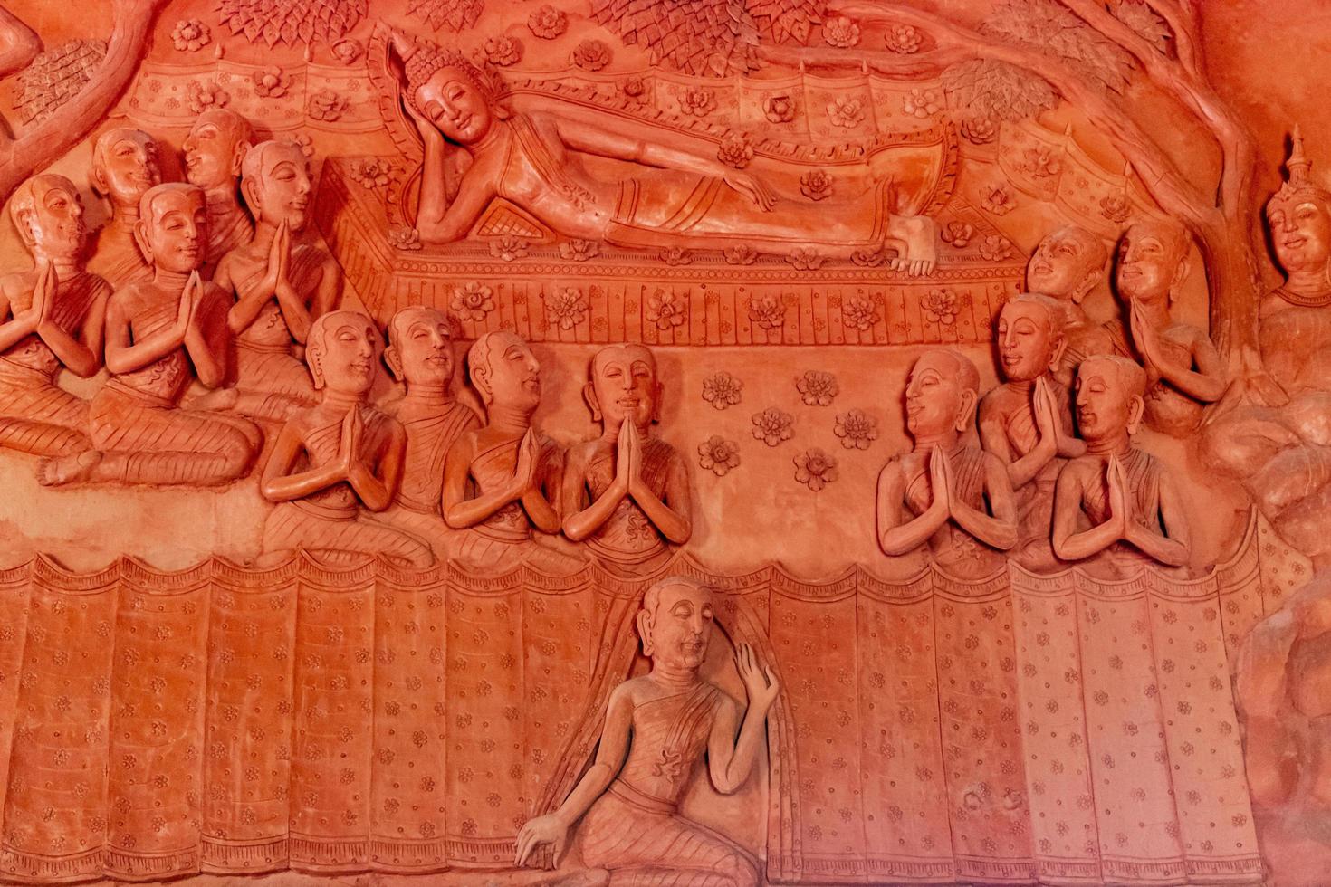 Prier des sculptures murales à wat sila ngu, le temple rouge, sur koh samui en thaïlande photo