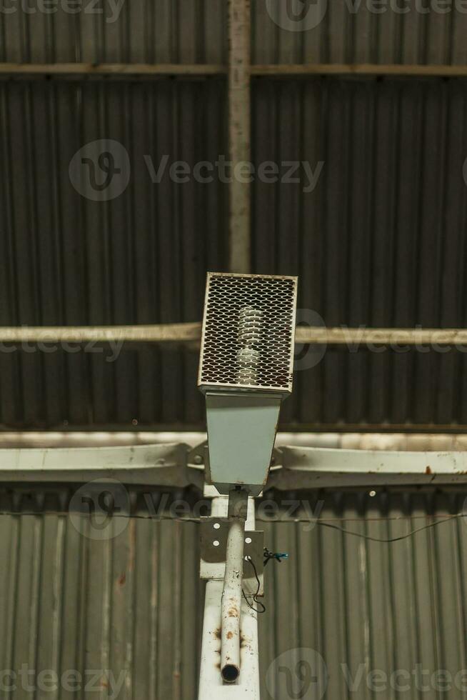 industriel lumière ampoule dans une protecteur câble cage, monté à le métal mur photo