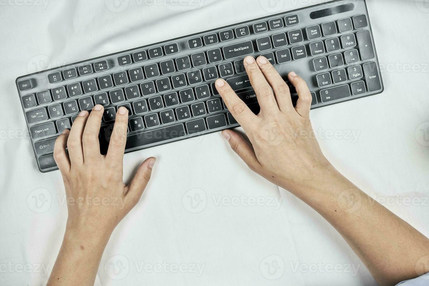 femme dactylographie sur sans fil clavier mensonge dans lit photo