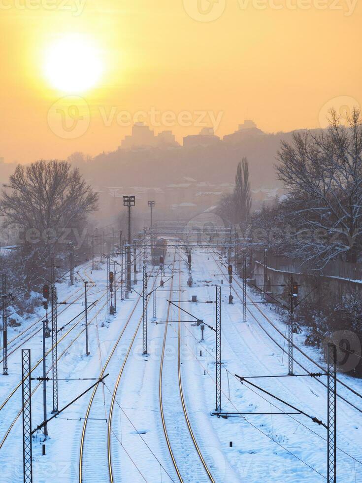 train des pistes dans hiver temps près industriel partie de le ville photo