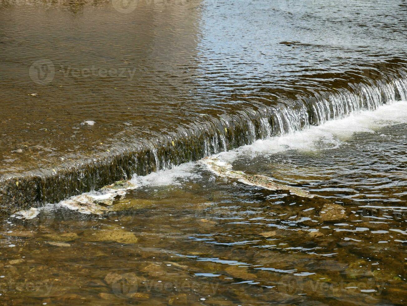 l'eau dans nature, peu cascade sur le rivière avec pur l'eau et des pierres photo