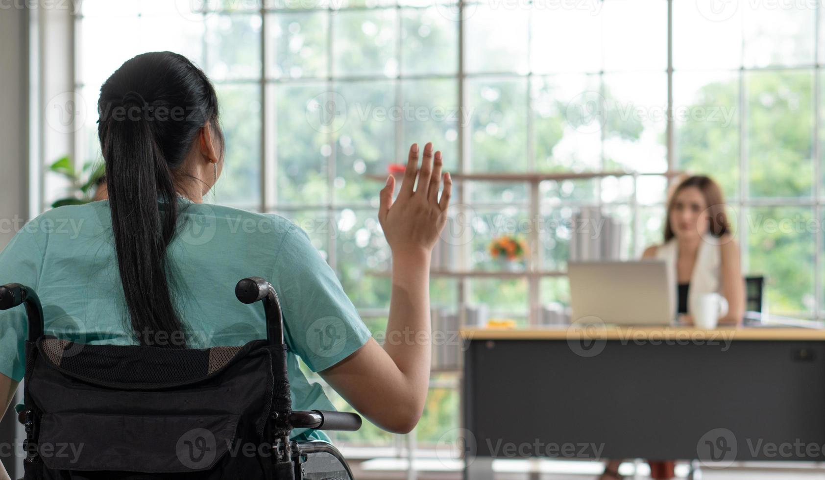 Jeune femme handicapée saluant un ami au bureau photo