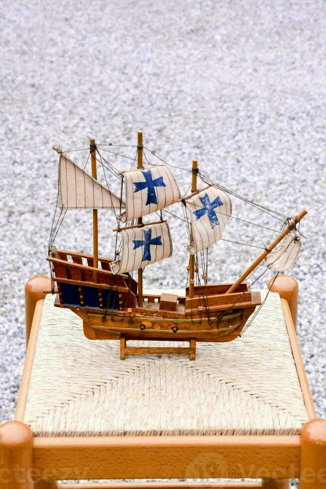 une en bois modèle de une navire séance sur une tabouret photo