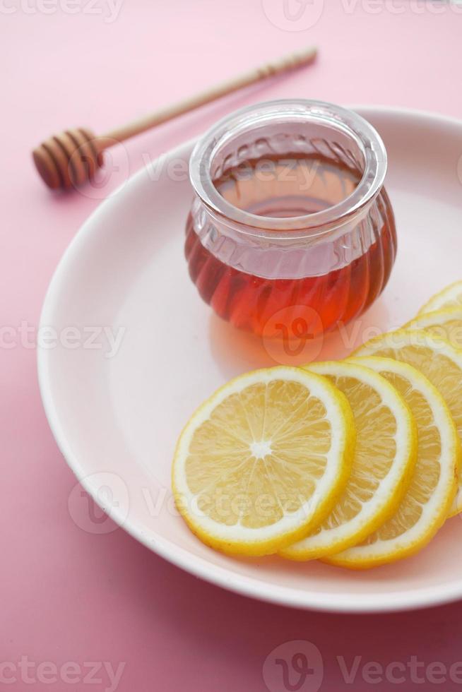 citron jaune et miel dans un bocal sur une assiette photo