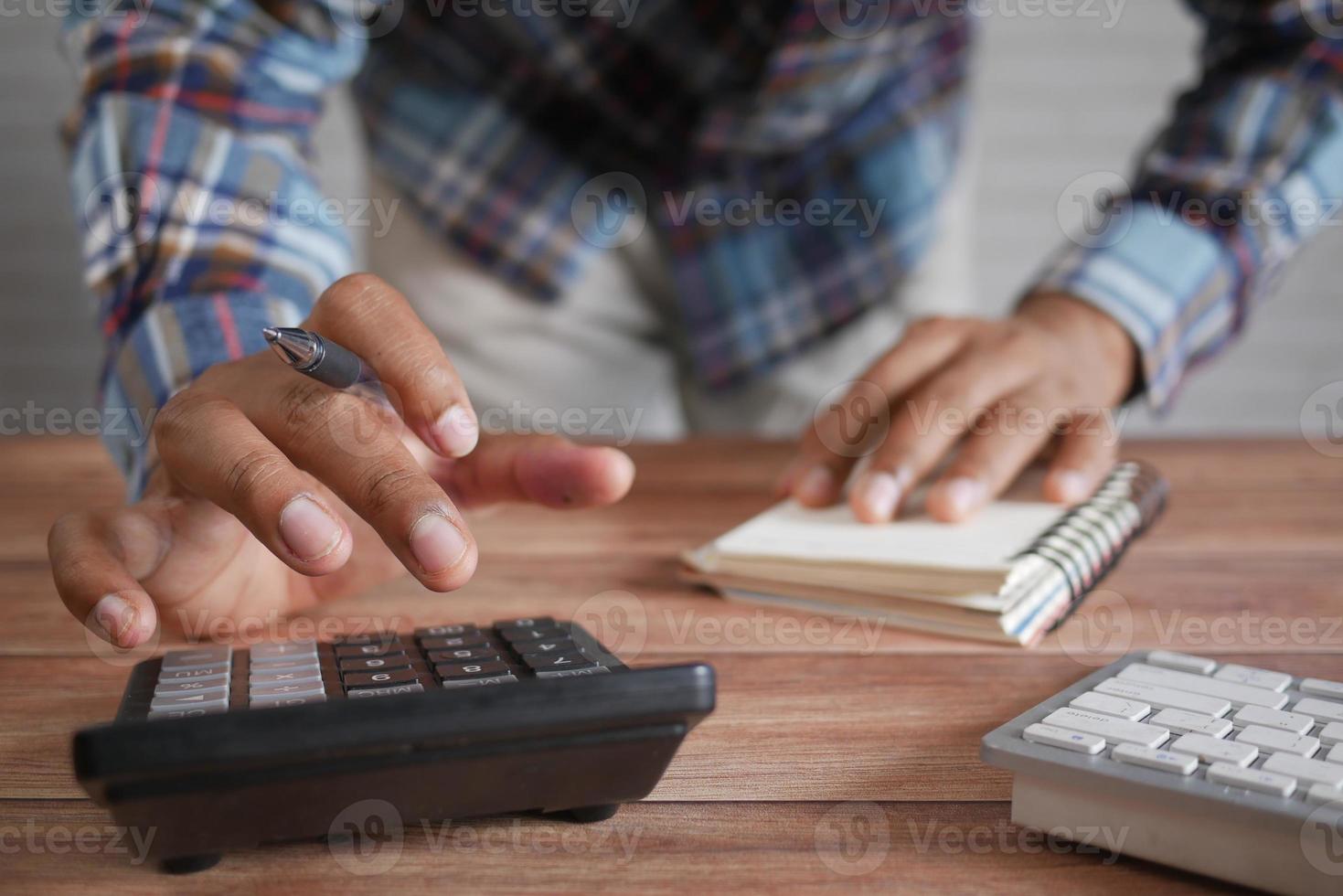 gros plan de la main de l'homme à l'aide de la calculatrice photo