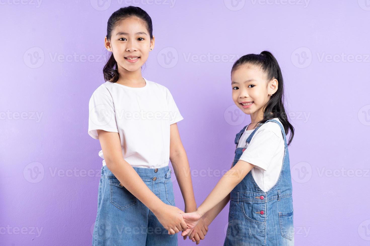 portrait de deux filles asiatiques sur fond violet photo