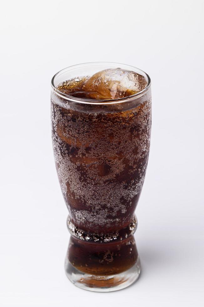 Cola en verre avec des glaçons clairs isolé sur fond blanc photo