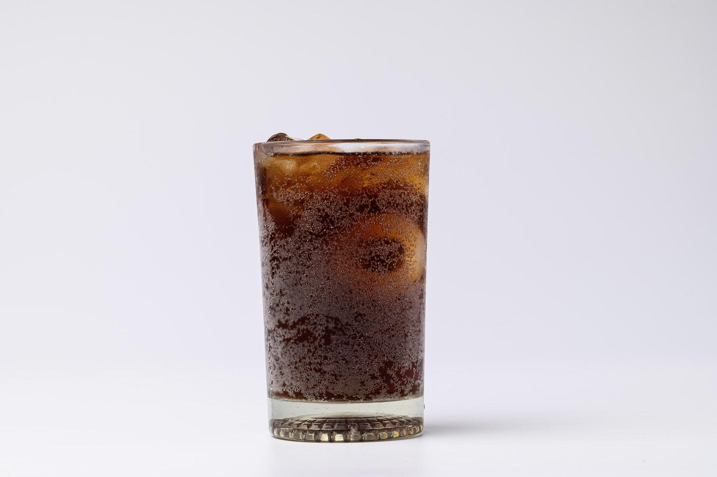 Cola en verre avec des glaçons clairs isolé sur fond blanc photo