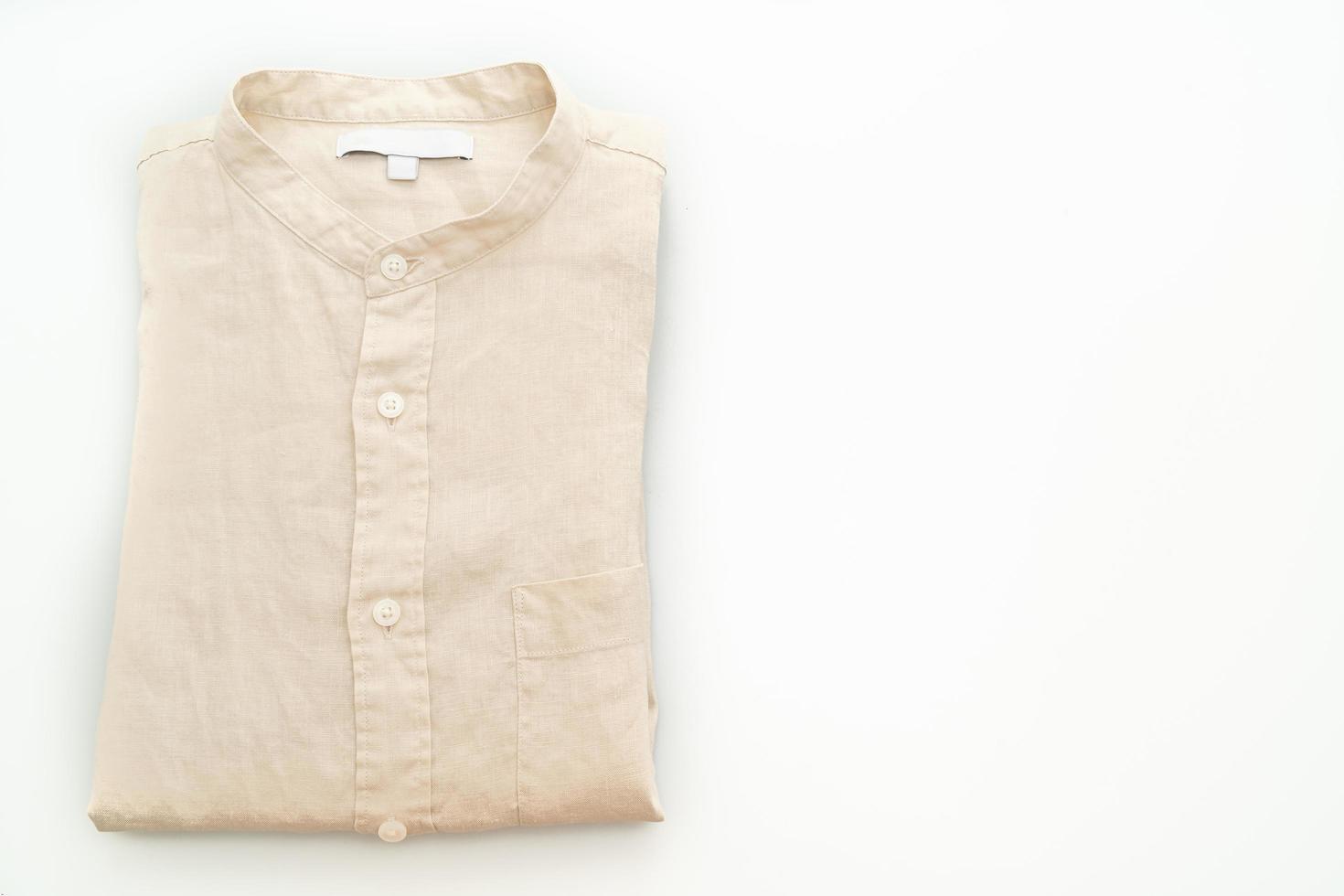 Chemise beige pliée isolé sur fond blanc photo