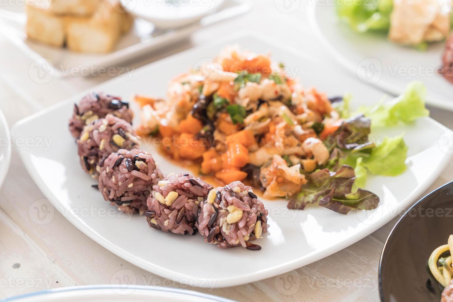 salade végétalienne épicée avec baies collantes et riz aux céréales photo