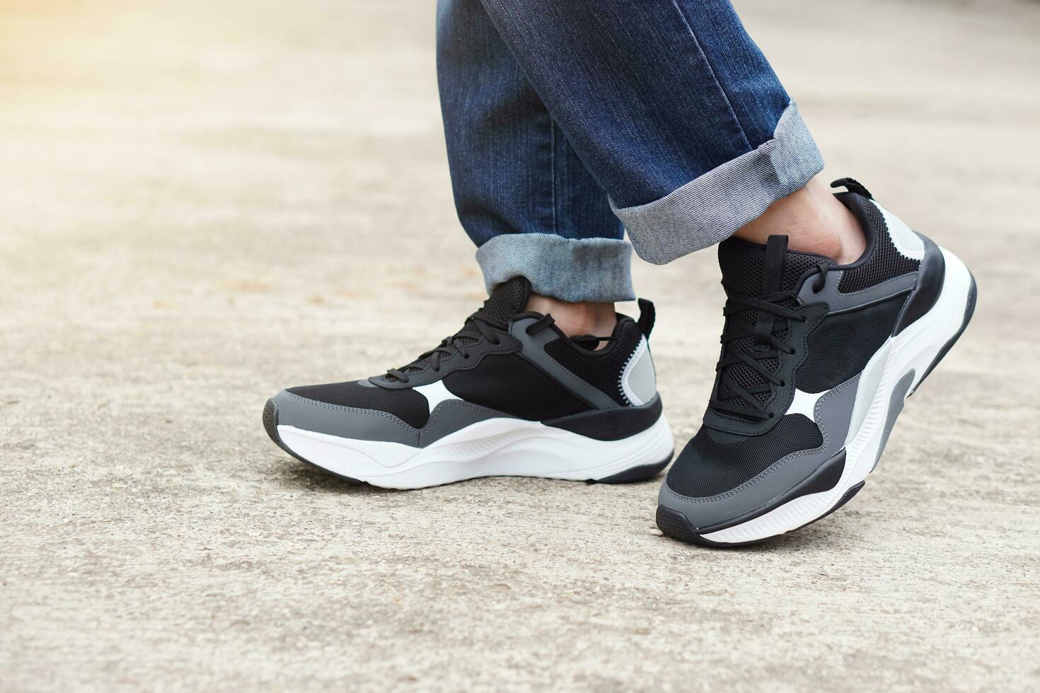 proche en haut Masculin adolescent porte baskets des chaussures et bleu jeans jambes. concept, mode, mode de vie. confortable chaussures et costumes pour Aller dehors, périple ou en voyageant. cool décontractée mode pour les adolescents photo