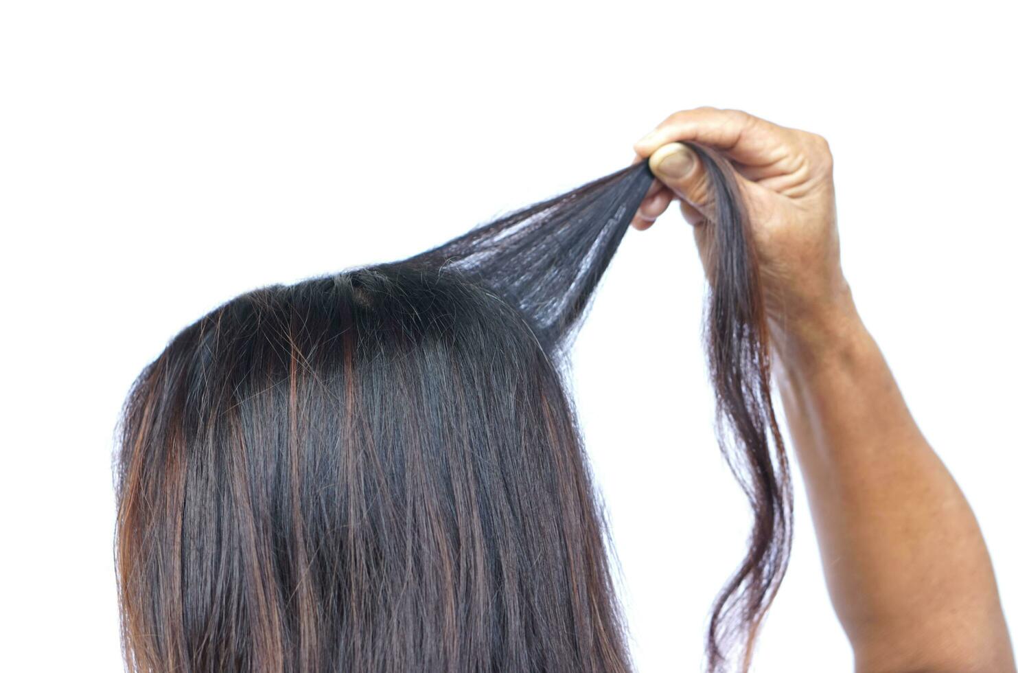 proche en haut femme main tirant sa cheveux, isolé sur blanc Contexte. concept, cheveux tirant désordre ou trichotillomanie. mental santé. psychopathe problèmes. photo