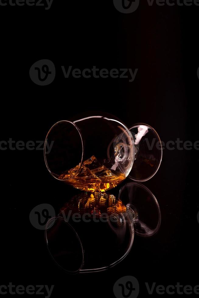 whisky avec de la glace en verre isolé sur fond noir photo