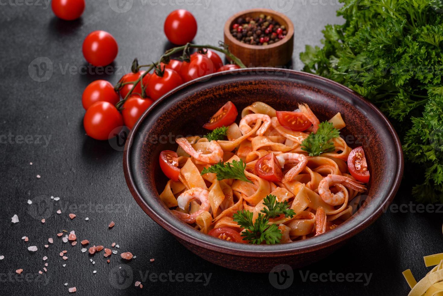 pâtes fettuccine aux crevettes, tomates cerises, sauce, épices et herbes photo