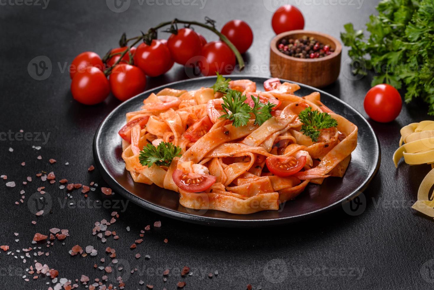 pâtes fettuccine aux crevettes, tomates cerises, sauce, épices et herbes photo