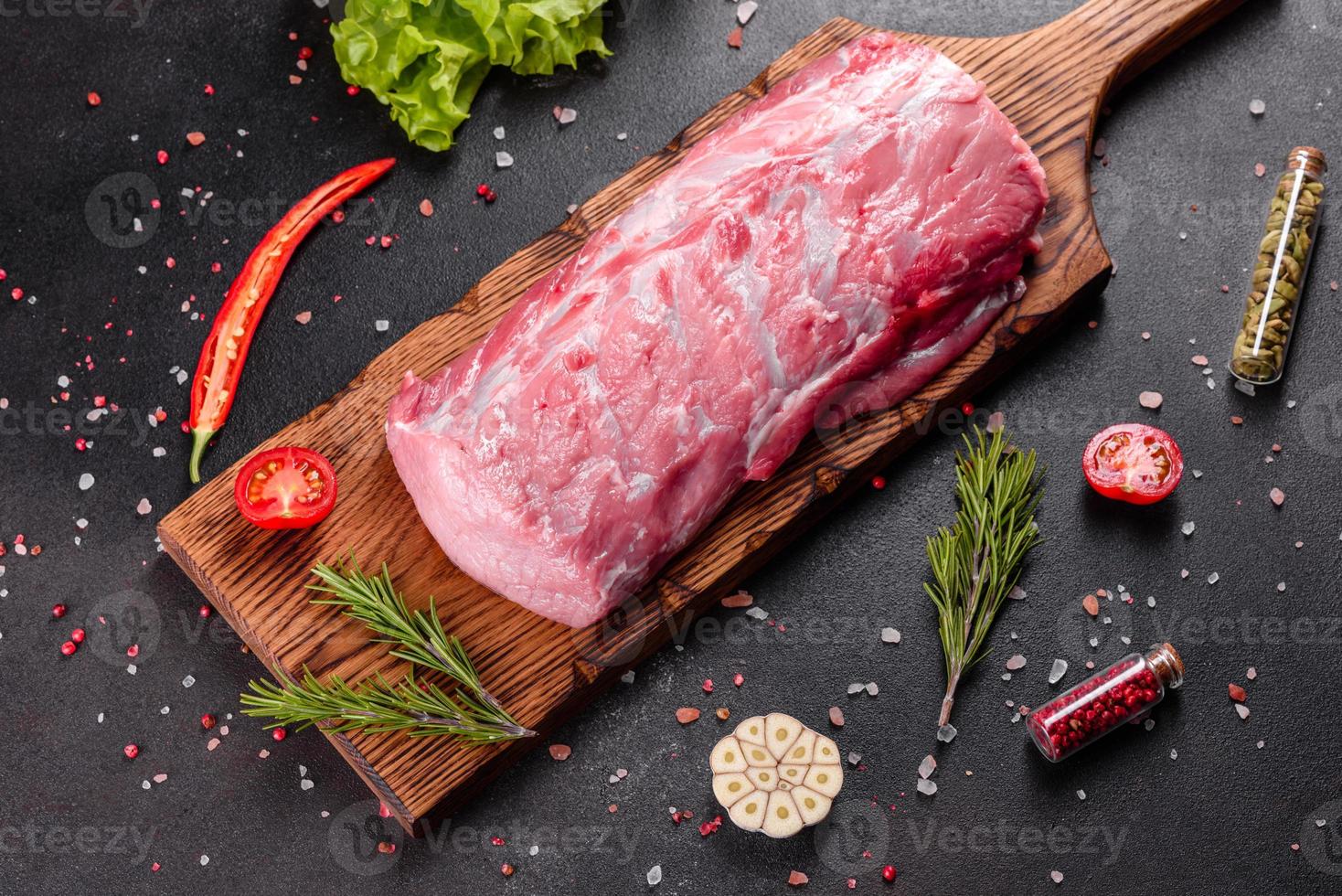 morceaux de porc frais prêts à cuire sur fond sombre dans la cuisine photo