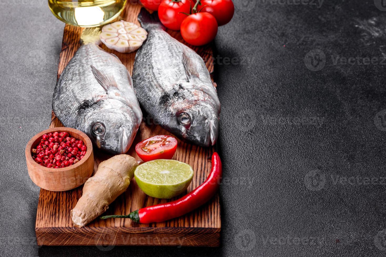 poisson dorado cru aux épices cuisson sur planche à découper photo