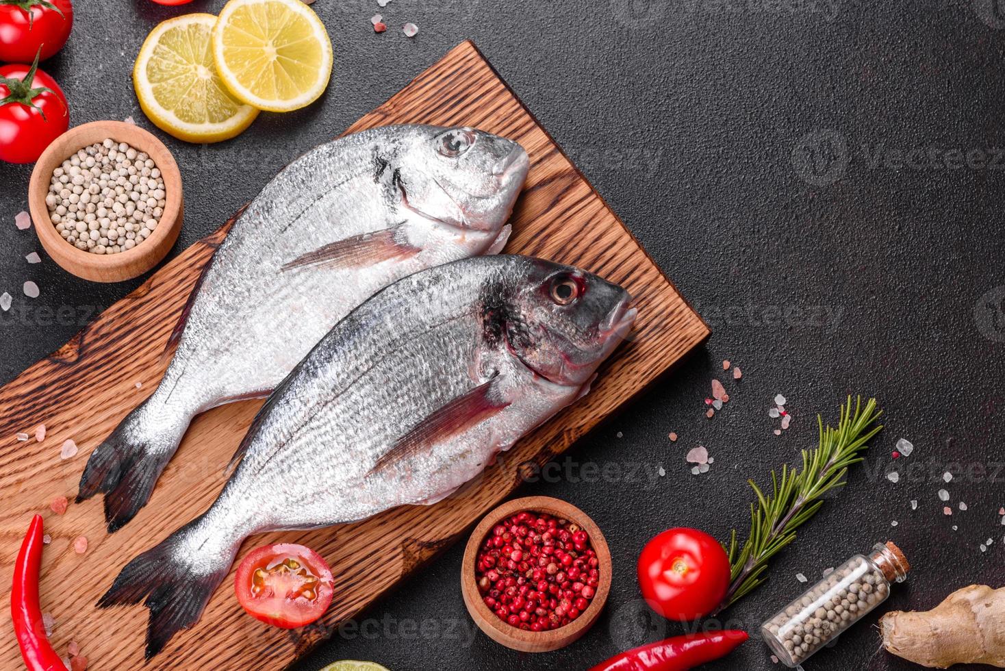 poisson dorado cru aux épices cuisson sur planche à découper photo