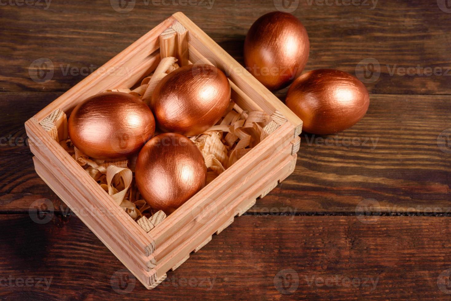 oeufs de pâques dans une boîte en bois cadeau sur fond de bois foncé photo