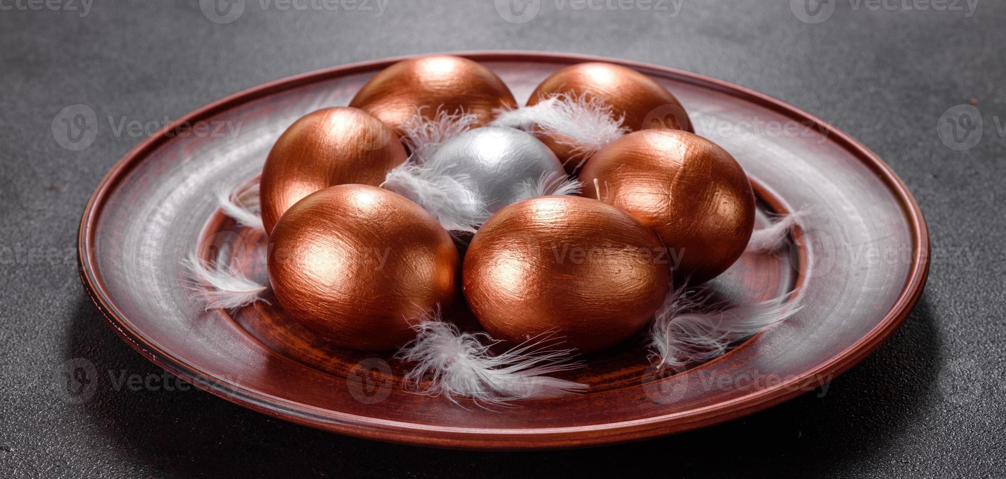 oeufs de pâques or et bronze et gâteau de pâques sur fond sombre photo