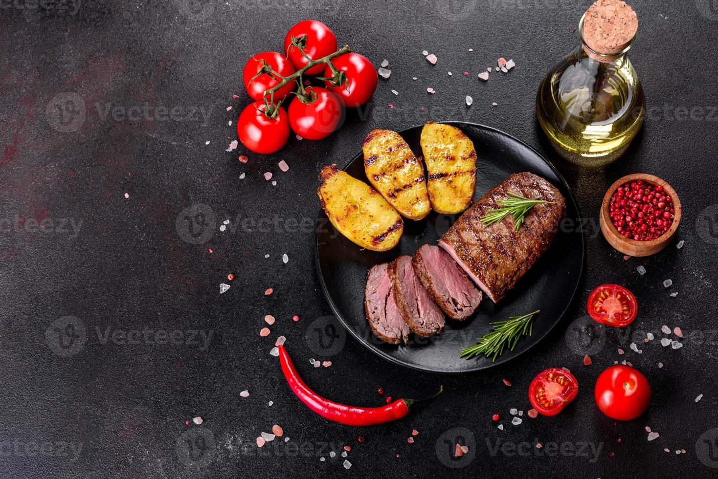 steak de faux-filet avec pommes de terre, oignons et tomates cerises photo