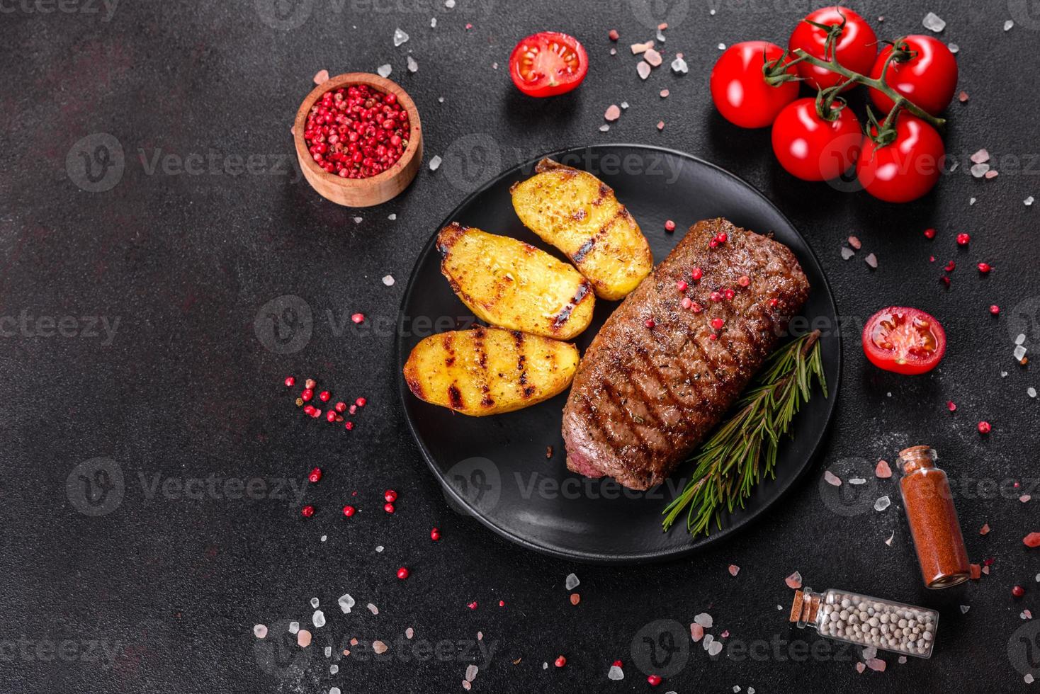 steak de faux-filet avec pommes de terre, oignons et tomates cerises photo