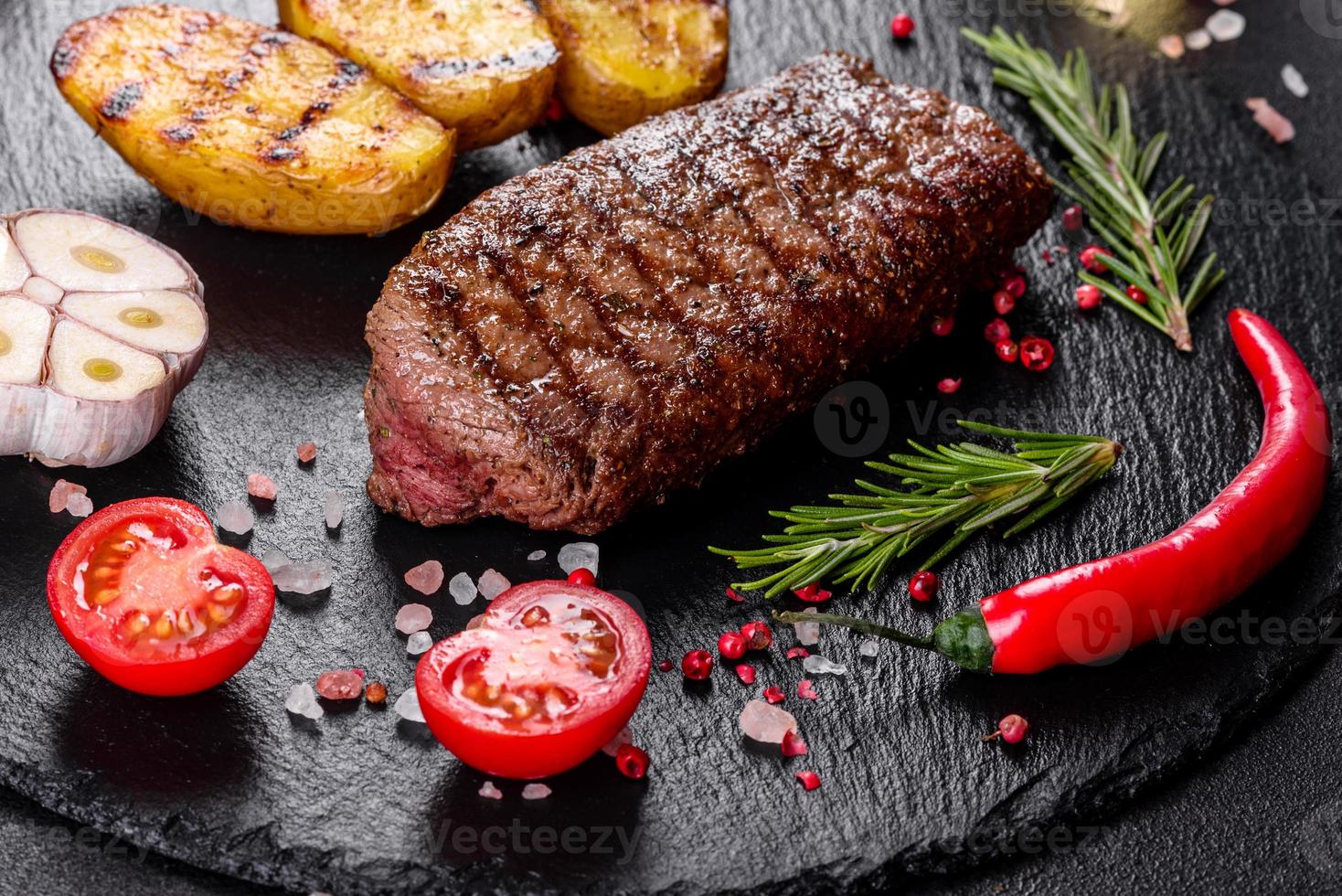 steak de faux-filet avec pommes de terre, oignons et tomates cerises photo